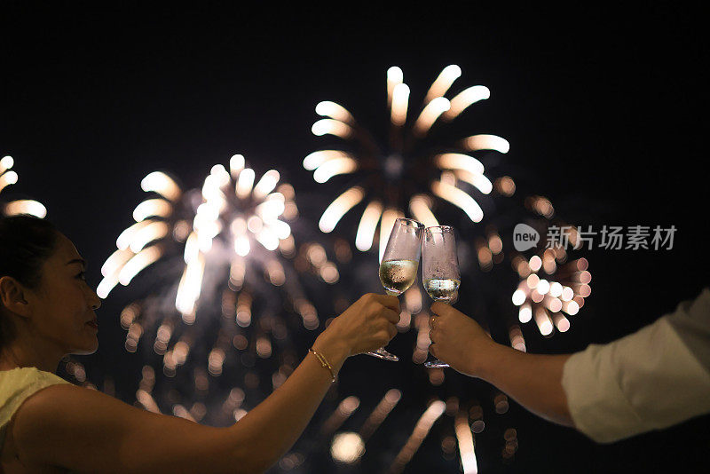 Party Celebration概念。手持香槟和红酒的女子手举杯敬烟花。圣诞节或新年庆祝活动